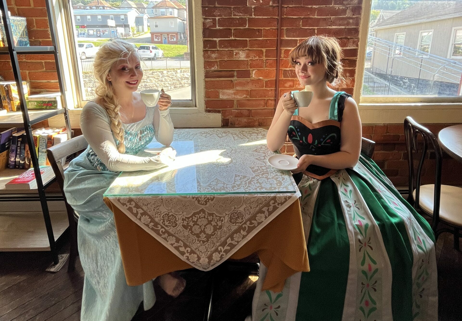 Two girls dress up as princess drinking tea